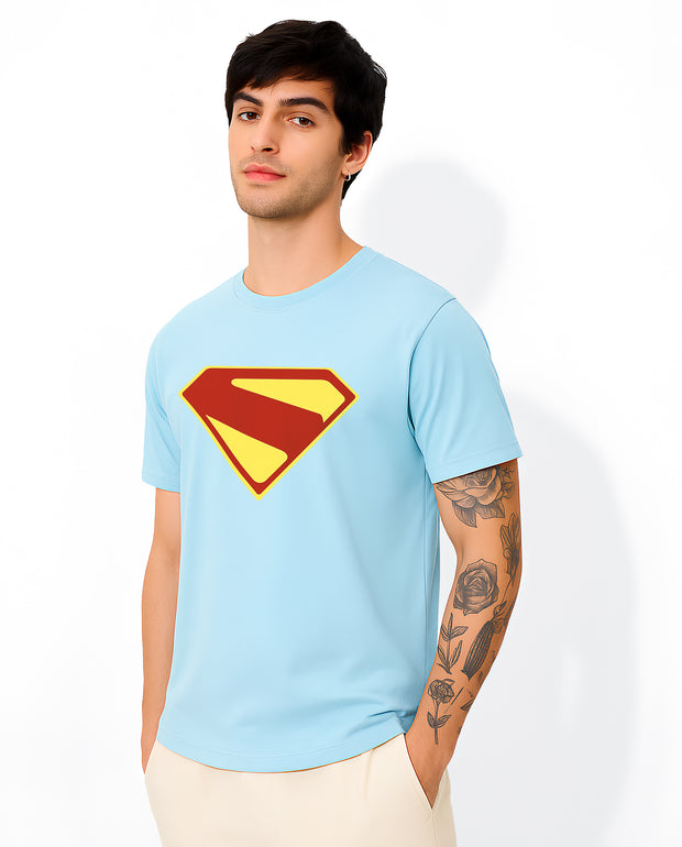 FantasyFit model wearing light blue Superman unisex t-shirt with red and yellow emblem showing tattooed arm and casual pose