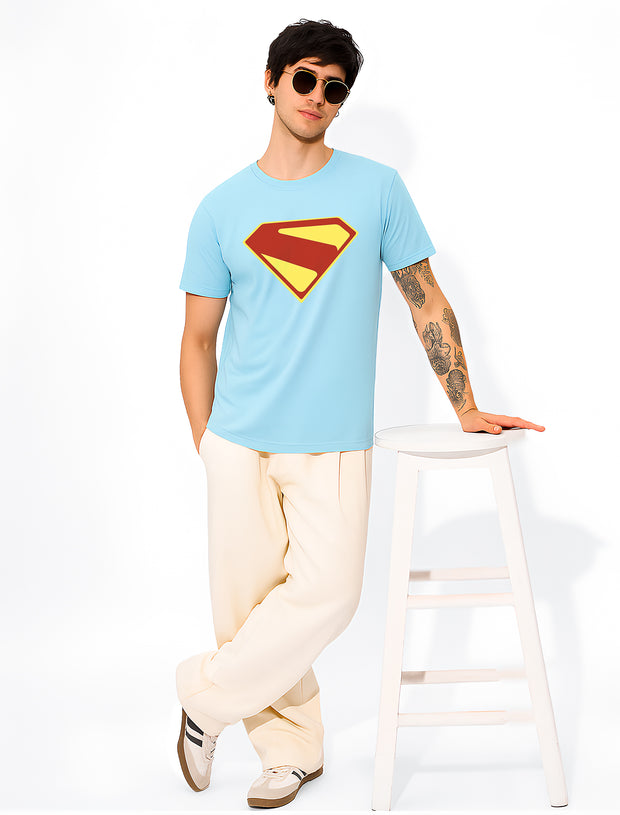 FantasyFit Superman unisex t-shirt light blue with large red yellow emblem worn by model leaning on stool